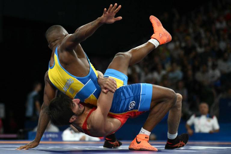 $!Slavik Galstyan (rojo) de Armenia lucha contra Andrés Roberto Montano Arroyo (azul) de Ecuador en su partido de lucha grecorromana masculina de 67 kg en las primeras rondas del Champ-de-Mars Arena durante los Juegos Olímpicos de París 2024. (Foto: AFP)