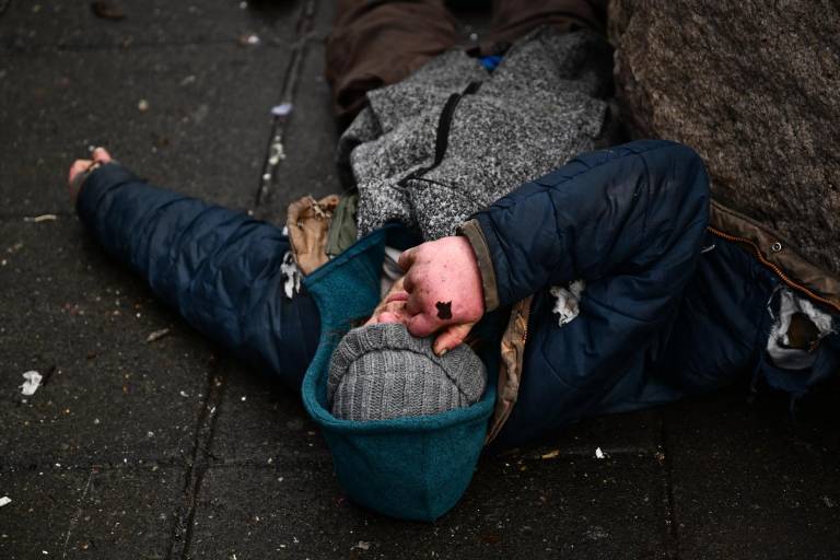 $!Una persona yace en la calle en el barrio Old Town Chinatown tras la despenalización de todas las drogas, incluido el fentanilo y la metanfetamina, en el centro de Portland, Oregón, el 25 de enero de 2024.