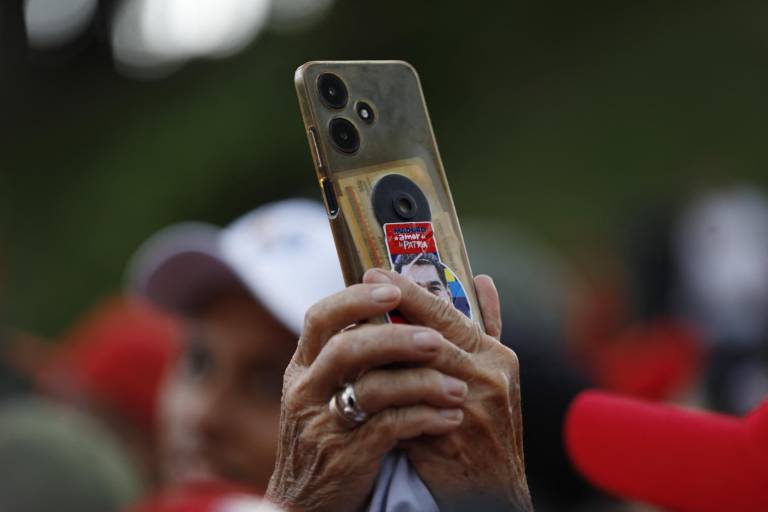 $!Una partidaria del presidente venezolano, Nicolás Maduro, toma una fotografía con su teléfono durante una manifestación en Caracas el 3 de agosto de 2024.