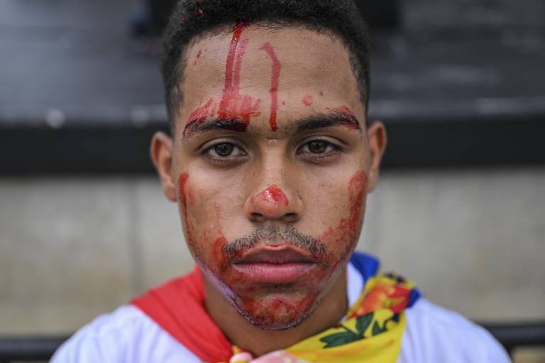 $!Frede Miles Jr. se pinta la cara de color rojo que representa sangre, mientras posa durante una protesta contra el proceso electoral de Venezuela y el presidente Nicolás Maduro en Miami, Florida, el 3 de agosto de 2024.