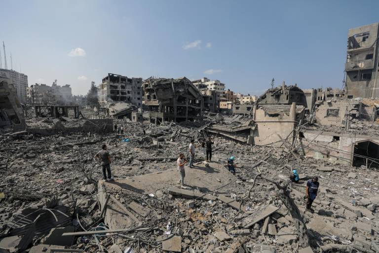 $!Personas en búsqueda de sobrevivientes en la zona de bombardeos.