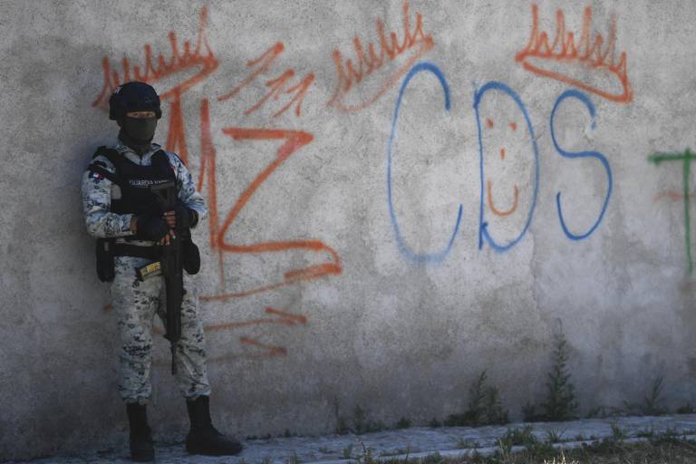 $!Un soldado mexicano hace guardia junto a unos graffitis del narcotraficante Mayo Zambada (MZ) y el grupo criminal Cartel de Sinaloa (CDS), en la aldea Palmas Altas, municipio de Jerez de García Salinas, estado de Zacatecas, México, el 14 de marzo. , 2022.