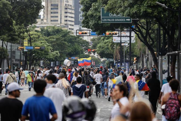 $!Personas recorren las calles durante una protesta por los resultados de las elecciones presidenciales este lunes, en Caracas (Venezuela).