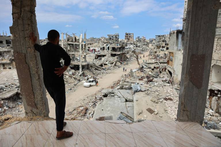 $!Un hombre palestino mira desde un edificio dañado un camino de tierra lleno de escombros en el barrio de Shujaiya de la ciudad de Gaza el 7 de octubre de 2024.