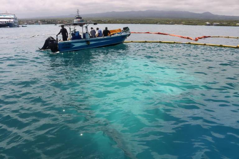 $!Guardabosques colocan material absorbente donde se hundió una embarcación el 23 de abril de 2022 cerca de Puerto Ayora en la Isla Santa Cruz.