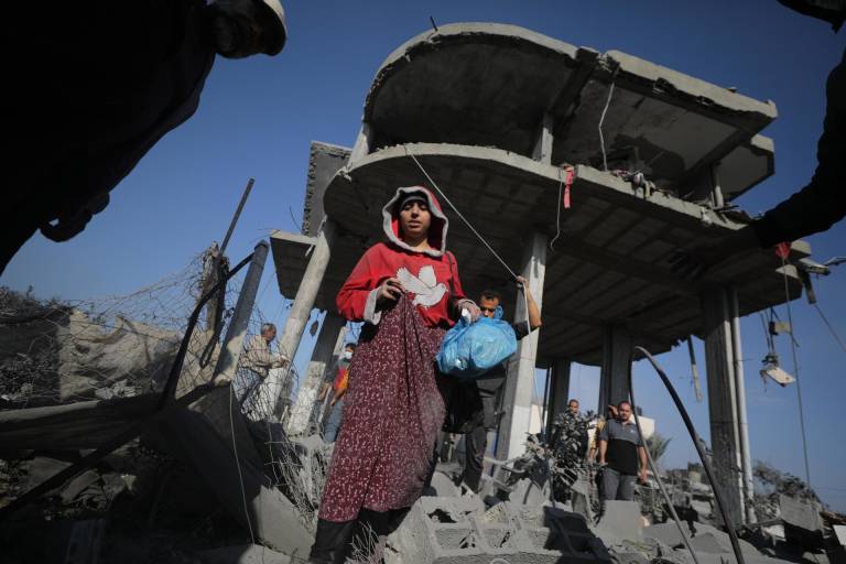 $!Palestinos en el lugar de una casa familiar destruida tras un ataque aéreo israelí durante una operación israelí en el campo de refugiados de Khan Younis, en el sur de la Franja de Gaza, el 31 de diciembre de 2023.