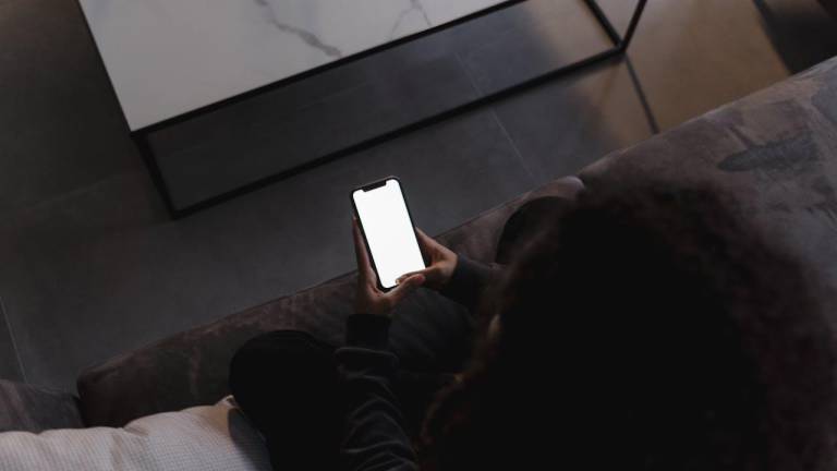 Fotografía referencial de una persona viendo su teléfono inteligente.