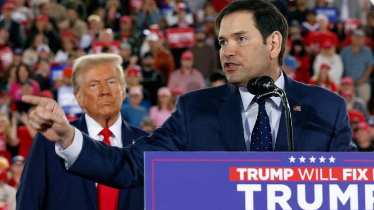 Donald Trump observa mientras el senador estadounidense Marco Rubio habla durante un mitin de campaña.