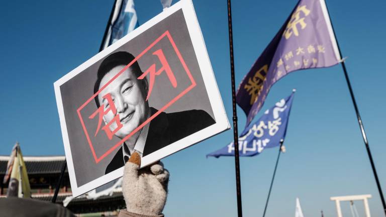 Un manifestante camina con un retrato del presidente surcoreano acusado, Yoon Suk Yeol, antes de una manifestación en Seúl el 11 de enero de 2025..