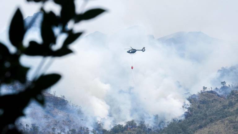 Fotografía sin fecha cedida por el Cuerpo de Bomberos de Cuenca de un helicóptero combatiendo un incendio forestal en el Parque Nacional Cajas, en Cuenca.