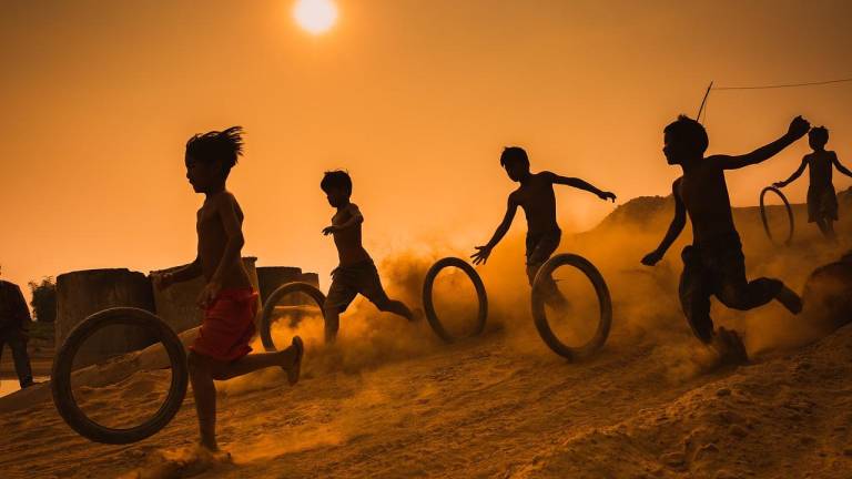 Fotografía de niños jugando en un parque con neumáticos.