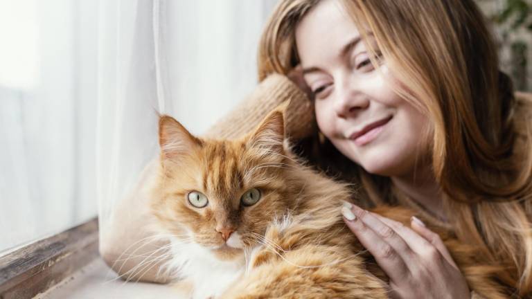 Una joven junto a su gatito.