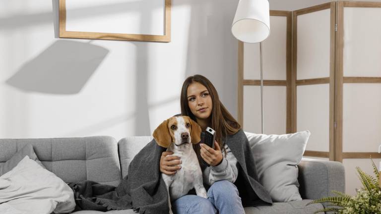 Una chica junto a su perro en su departamento.