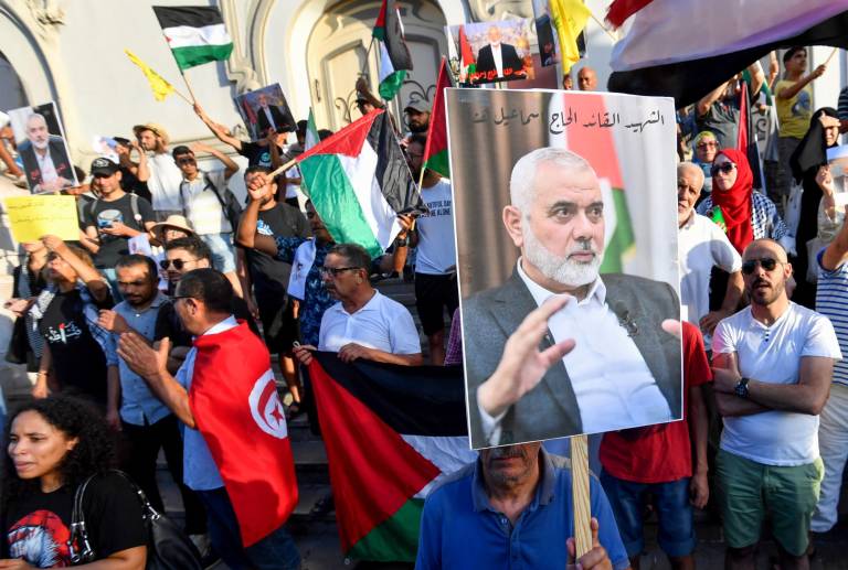 $!Los tunecinos ondean banderas palestinas y sostienen retratos del líder asesinado del grupo militante Hamas, Ismail Haniyeh, durante una protesta en la capital Túnez el 31 de julio de 2024, denunciando su asesinato.