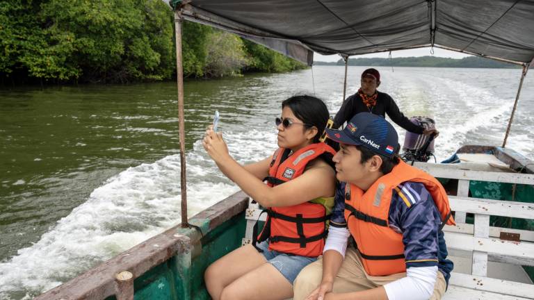 Fotografía de dos jóvenes navegando en el Golfo de Guayaquil.