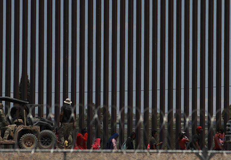 $!Policías de la Guardia Nacional de Texas dialogan por medio de altavoces con migrantes este viernes, en el muro que divide a México con Estados Unidos, en Ciudad Juárez.