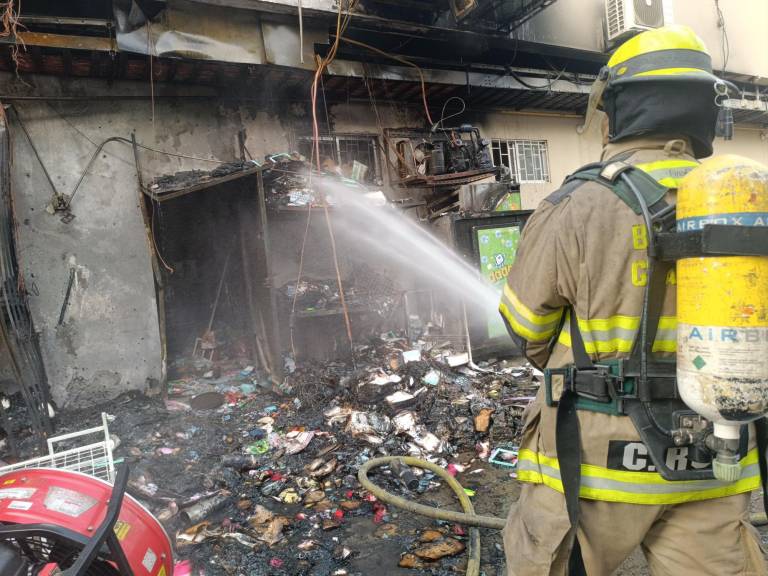 $!Un bombero apagando llamas restantes.