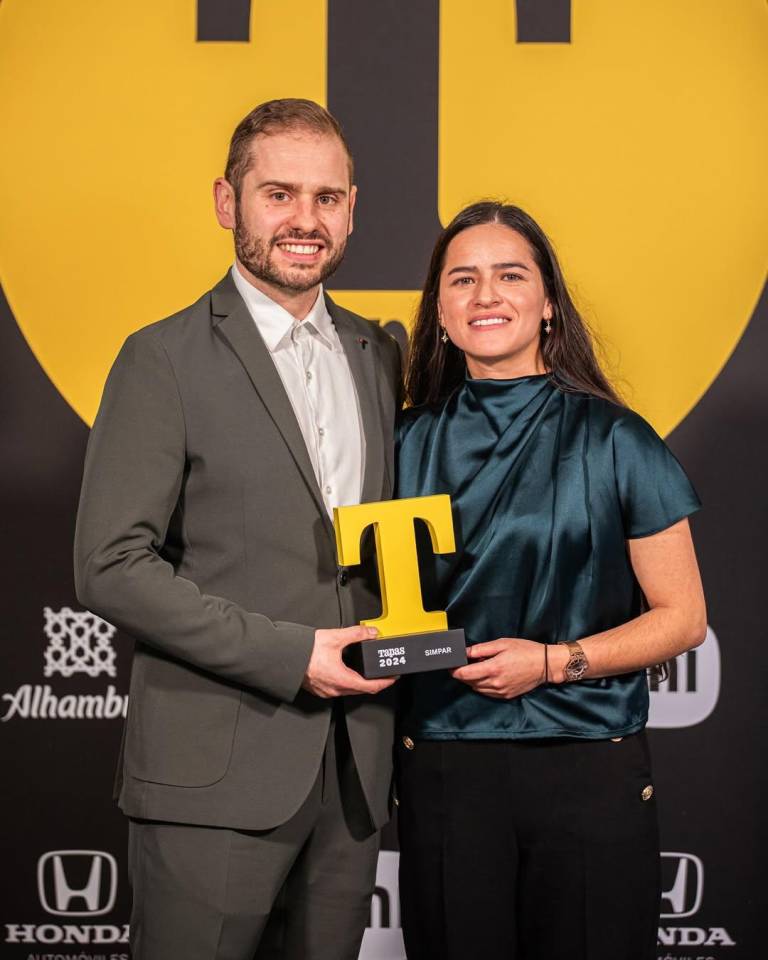 $!Los chefs Áxel Smyth y Claudia Merchán sosteniendo el reconocimiento T de Oro de la revista Tapas de España.