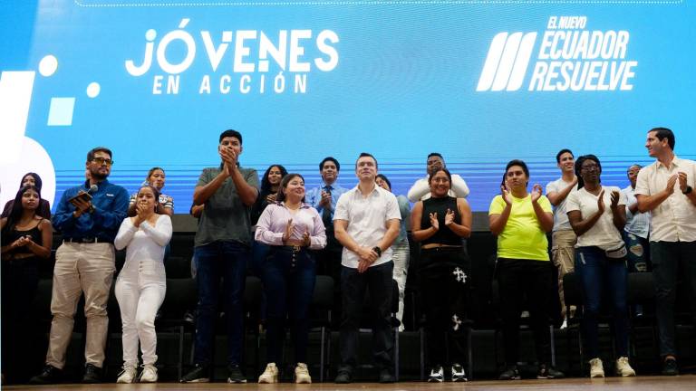 El presidente Daniel Noboa (C) y el ministro de Transporte y Obras Públicas, Roberto Luque (último a la derecha), rodeados de jóvenes que acudieron a la socialización del proyecto.