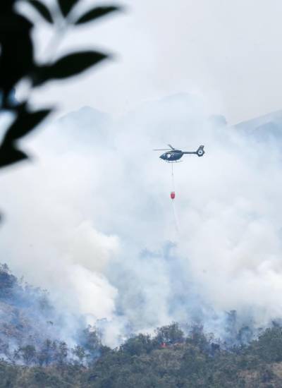 Fotografía sin fecha cedida por el Cuerpo de Bomberos de Cuenca de un helicóptero combatiendo un incendio forestal en el Parque Nacional Cajas, en Cuenca.